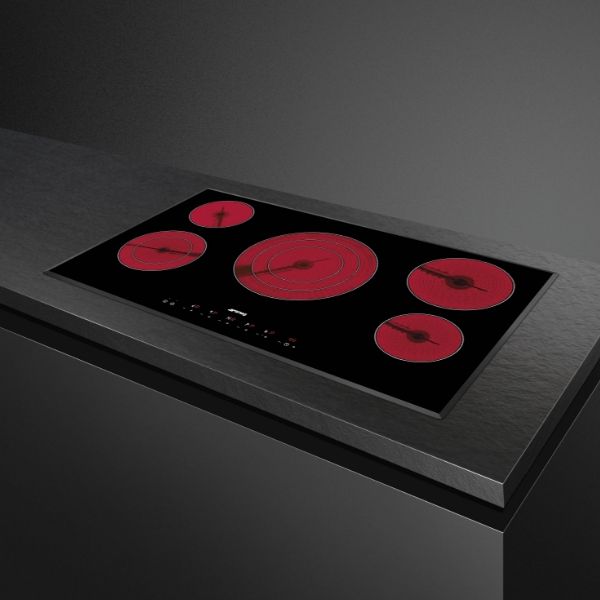 A smeg Ceramic hob in black with 5 glowing red cooking zones