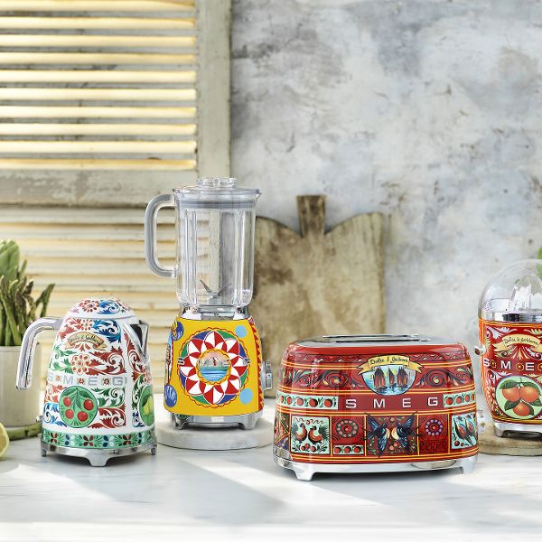 A predominantly red,  2 slice designer toaster from Smeg's 'Sicily is my love' range, featuring a vibrant special abstract design of birds, boats, food and more