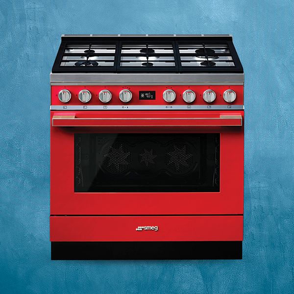 A range cooker in vibrant red, set against a blue backdrop. The range cooker features a 6 burner gas hob