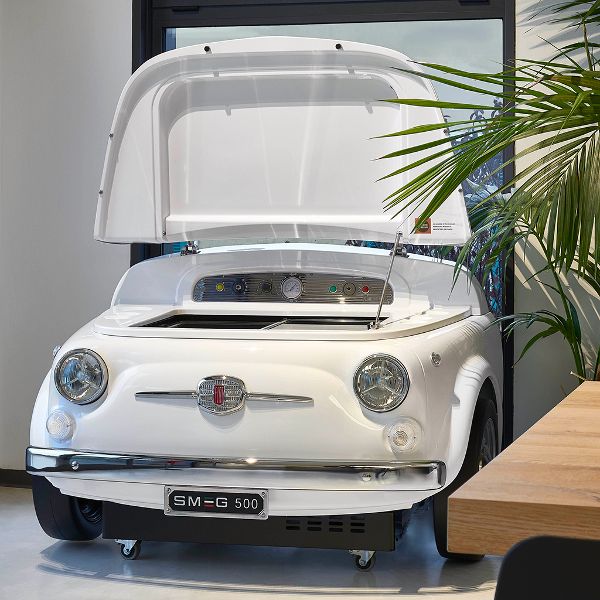 Smeg's Fiat 500 fridge in white. This designer refrigerator  resembles the front end of a Fiat 500, with the bonnet open to reveal a top-opening cooler perfect for storing drinks or wine.