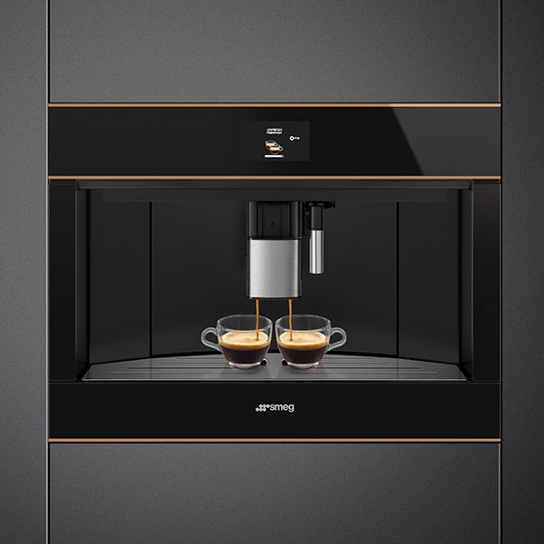 A contemporary built-in coffee machine in black, with bronze trim and a single touch control panel, simultaneously pouring two coffees