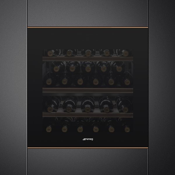 A built-in wine cooler in black with bronze trim top and bottom. Darkened glass provides visibility of the 27 bottles within