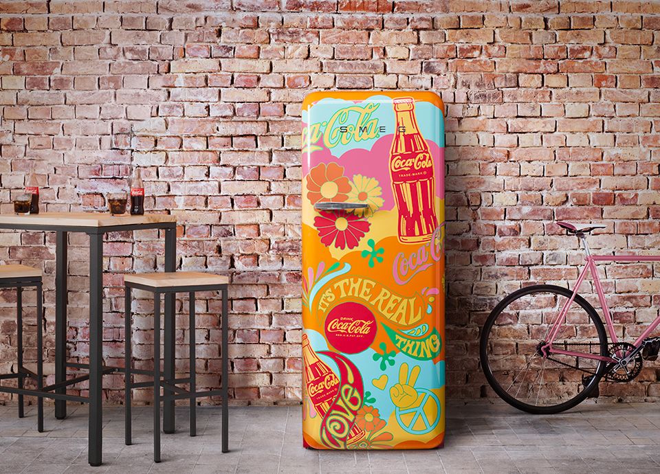 Smeg's Coca Cola branded fridge freezer in vibrant retro-pop, 60's 'hippy' style showing peace icons, stylised flowers