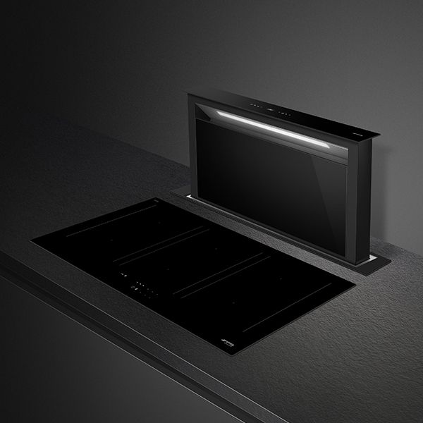 Popup downdraft extractor hood in black, integrated within a worktop with a long built in light