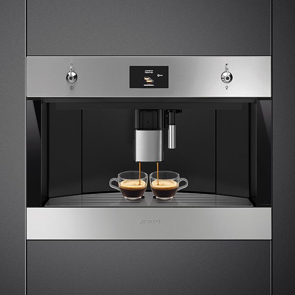 A built-in stainless steel coffee machine, with dual spouts, pouring two cups of espresso simultaneously