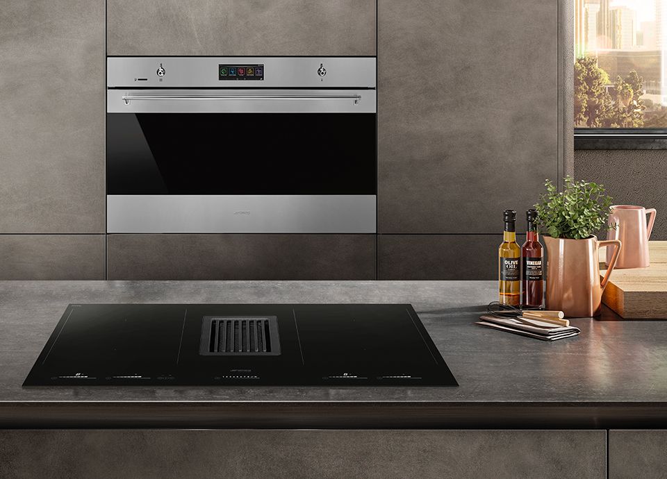 A silver 90 cm oven with black glass, built into sleek, modern kitchen units with a marble appearance