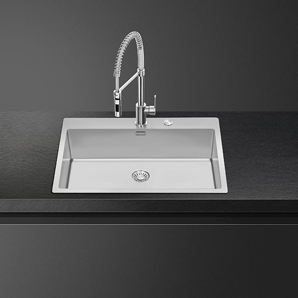 A flush fitted kitchen sink in stainless steel. Also shows a pull-out spray tap