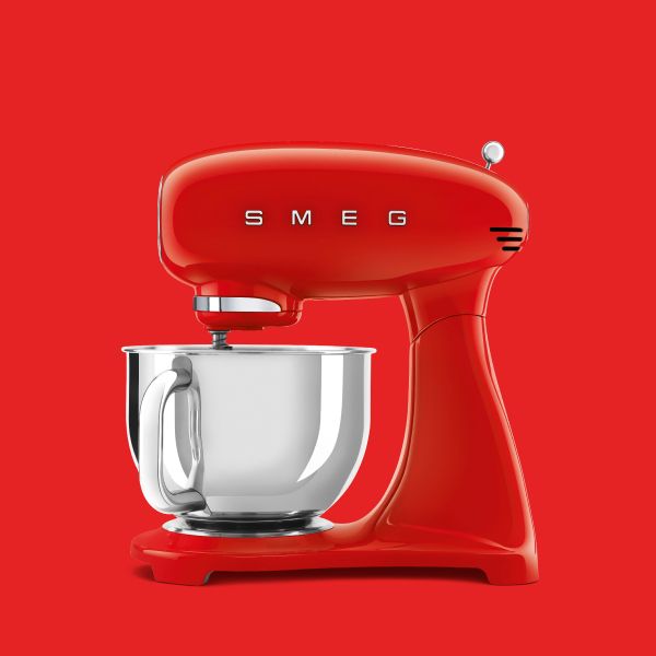 A retro stand mixer with a vibrant red head unit, stand and base. On it sits a stainless steel (highly polished) food bowl with a handle