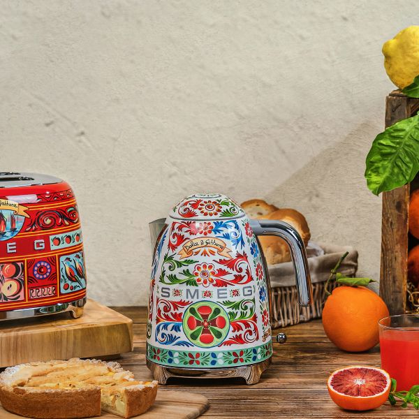 A designer kettle featuring Smeg and Dolce & Gabbana 'Sicily is my love' design or red blue and green organic patterns resembling curled vine leaves